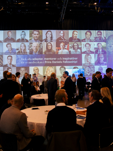 människor runt bord med foton på entreprenörer som bakgrund